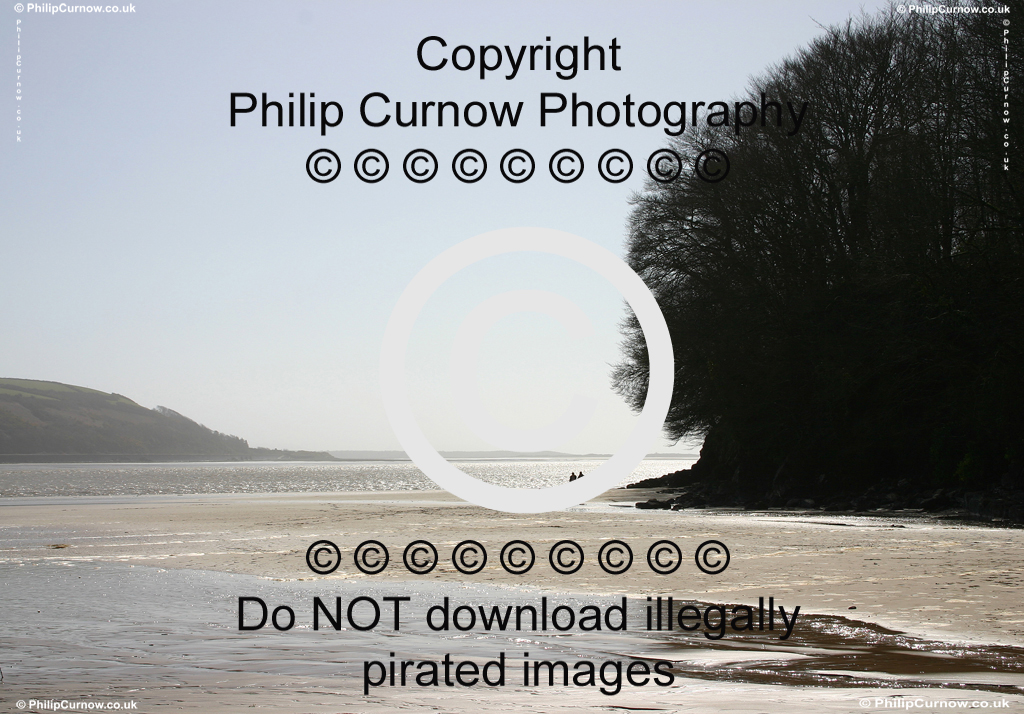 Couple walking hand-in-hand on beach at Llansteffan