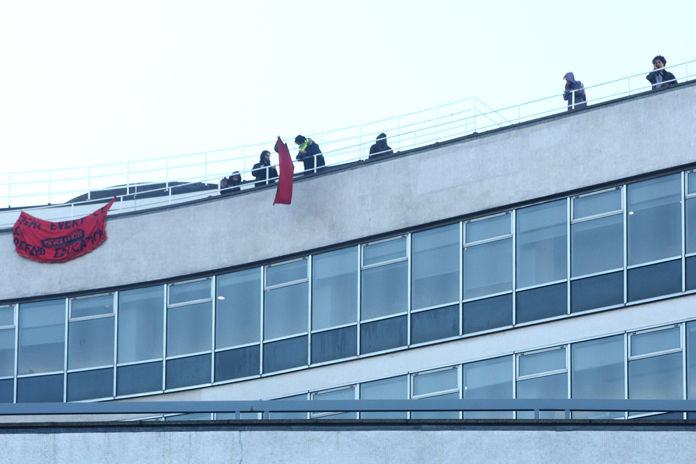 Rioters on top of the Conservative Offices in London, protesting against education cuts.